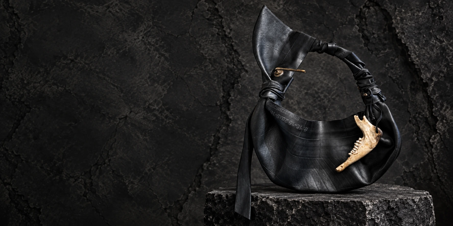 RELIC — the special vehicle tyre rubber and bone bag, photographed alone on dark stone